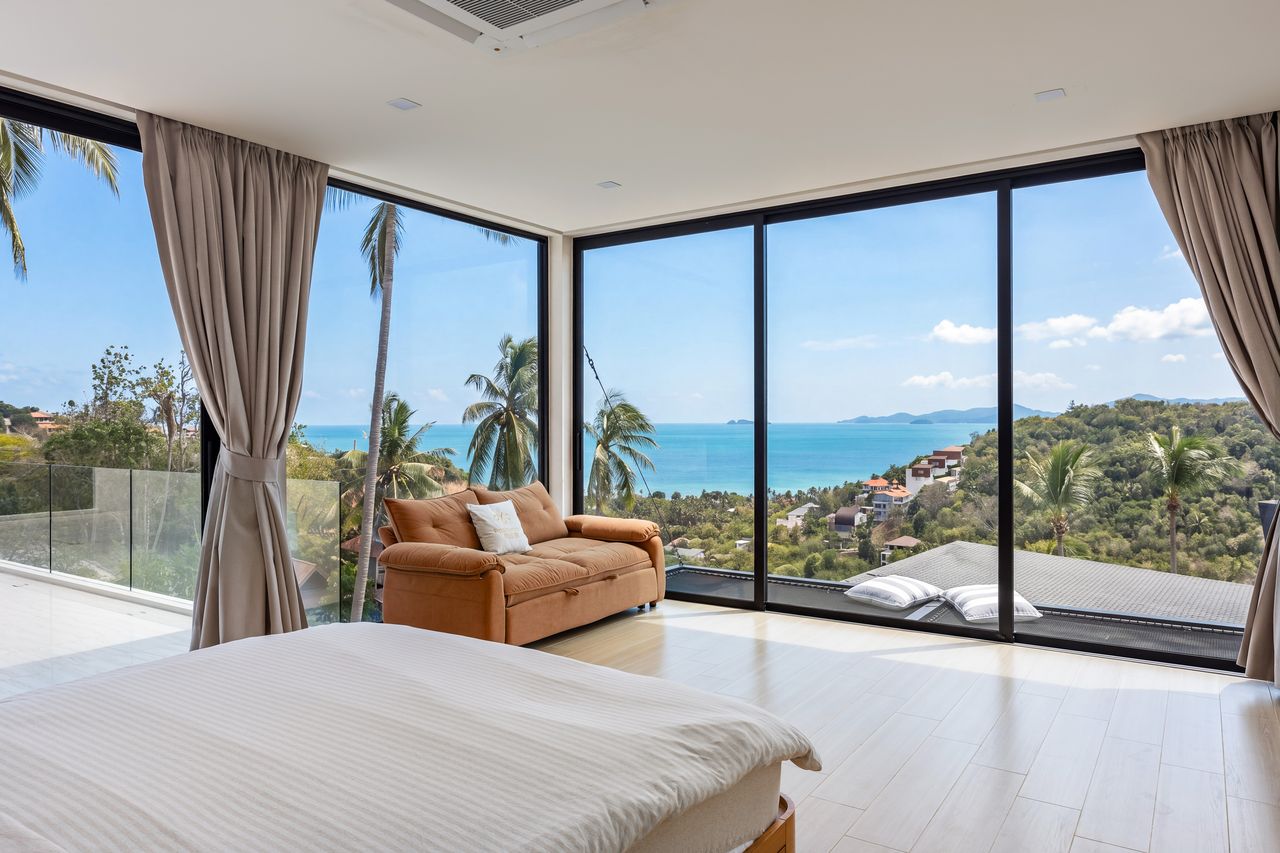 The master bedroom with floor-to-ceiling windows and a sea view
