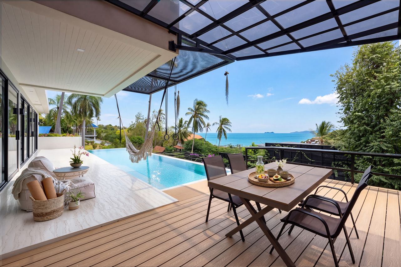 The pool deck with dining table and a view over the sea