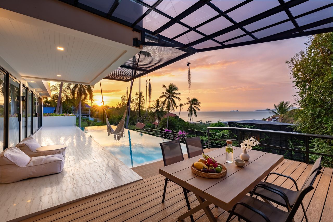 The pool deck at sunset, with a hammock and the sea beyond