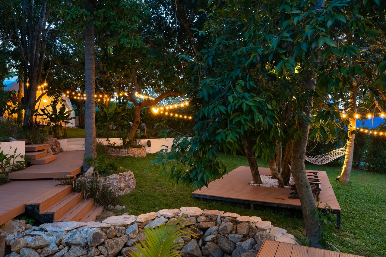 Garden decks, a stone fire circle and string lights at dusk
